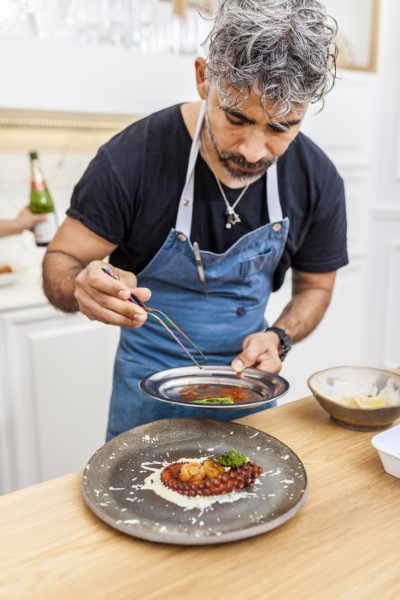 Picture of a private chef Aspen, cooking octopus with vegetables.