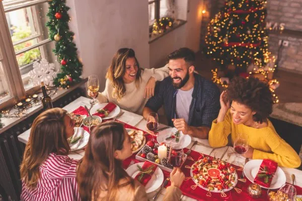 Happy family enjoying a dining Christmas in Aspen prepared by Seduction Kitchen, the best catering company around mountains !